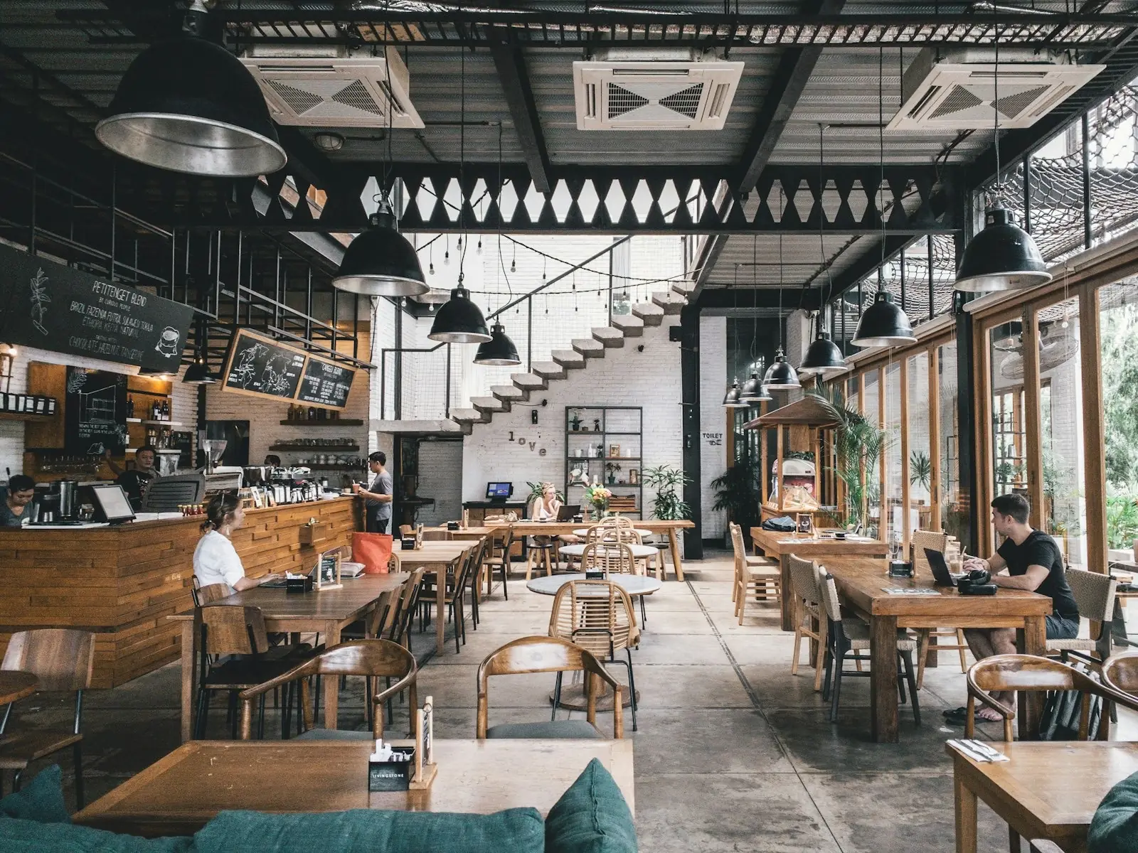 A busy modern café in full service, staff working behind the counter