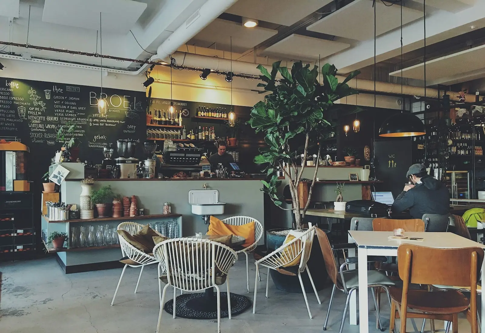 A guest with coffee and a laptop at a café counter
