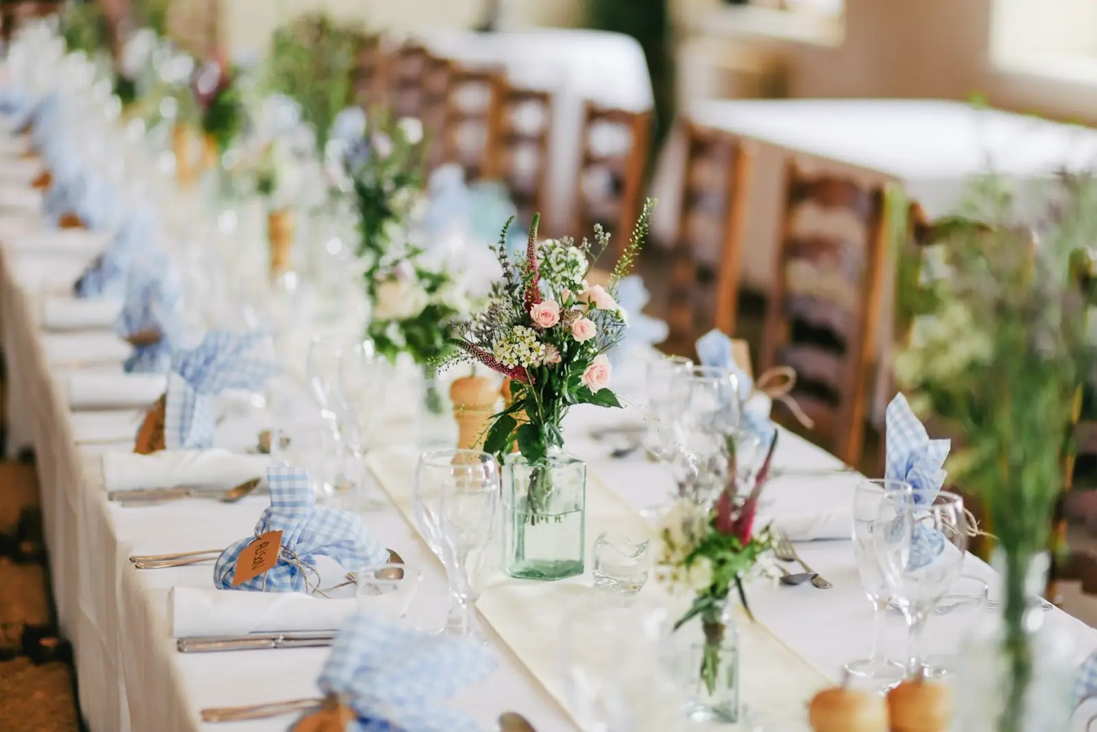 A long wedding table dressed with flowers and place settings